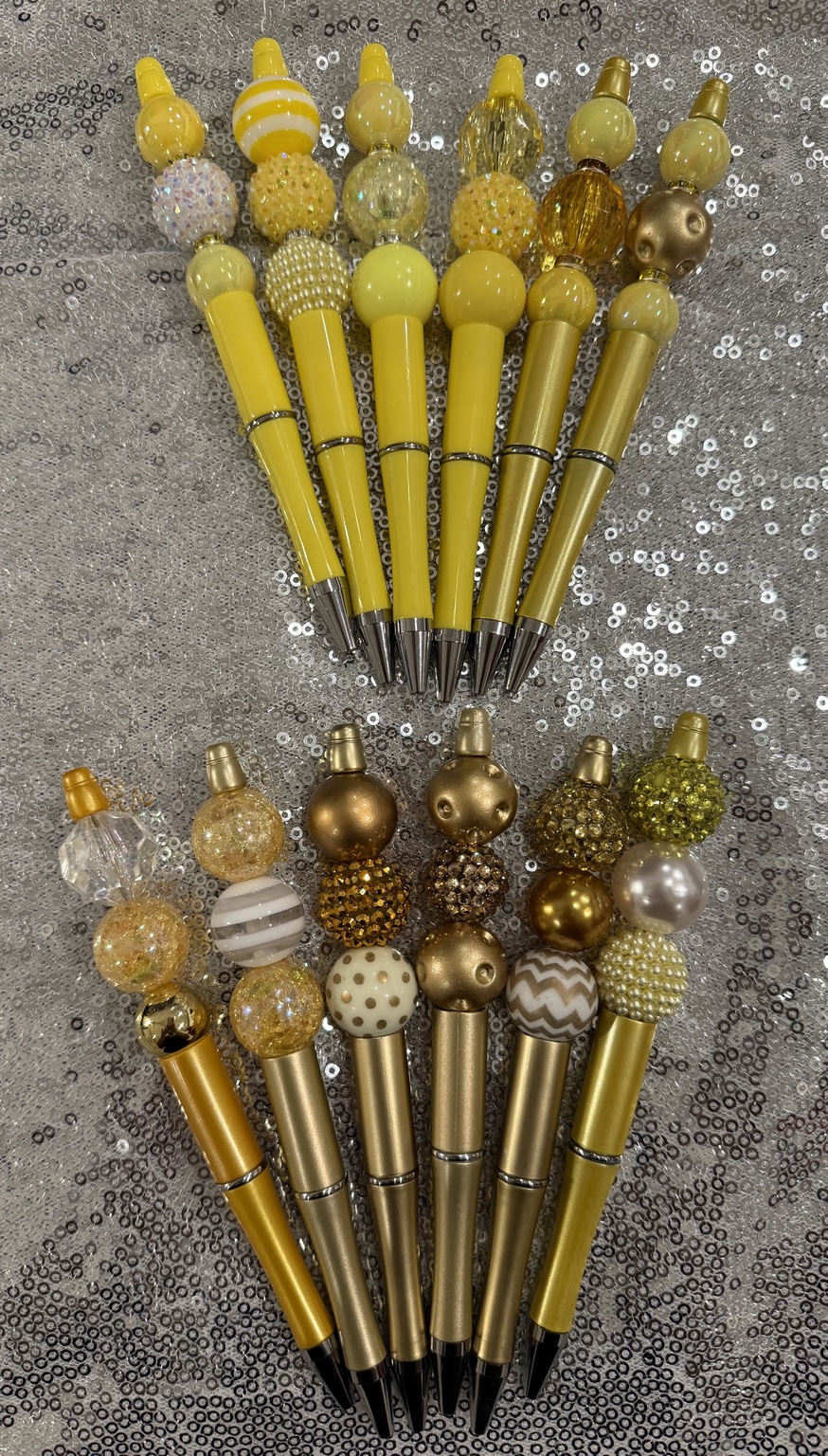 The full collection of yellow and gold handmade beaded pens, shown with all beads and pen tips visible